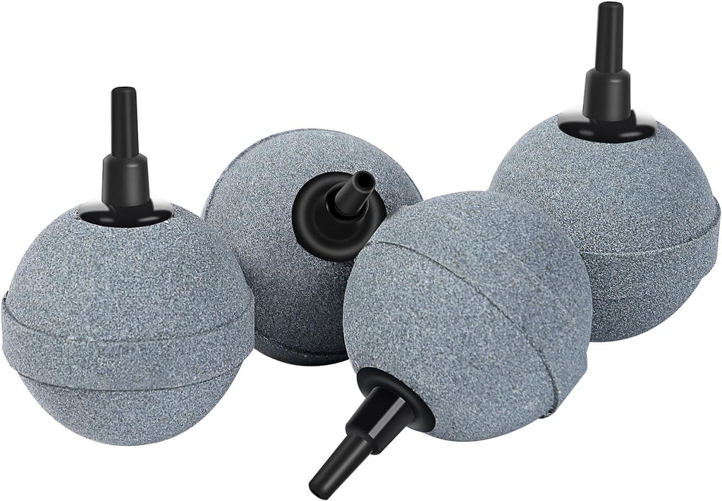 Four 2-inch aquarium air stones producing ultra-fine bubbles inside a freshwater fish tank to improve oxygen levels for tropical fish and aquatic plants.